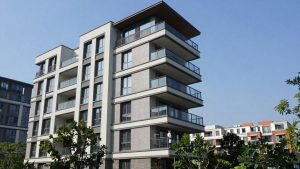 Clădire modernă cu cer senin și copaci verzi.